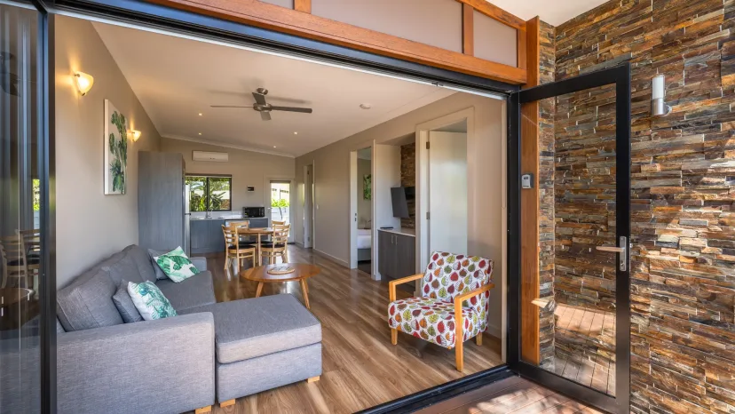 Apartment lounge with a sofa and bi-fold doors opening onto a private deck