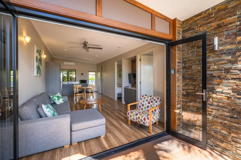 Apartment lounge with a sofa and bi-fold doors opening onto a private deck