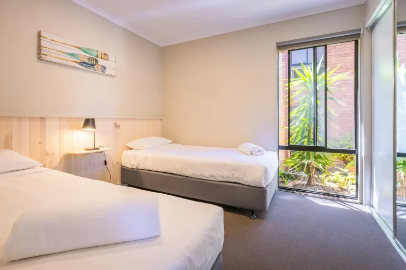 Second bedroom with two single beds and a garden window