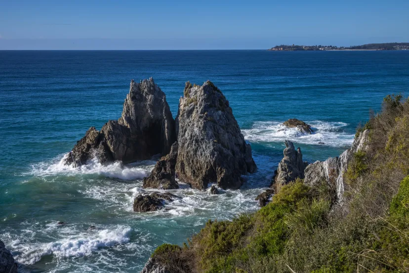 Camel Rock at Bermagui, two tall sea stacks standing in turquoise water with surf breaking around them
