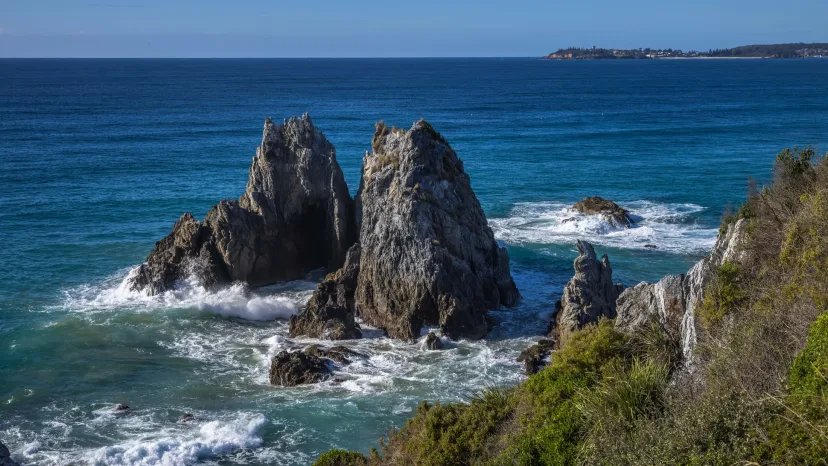 Camel Rock at Bermagui, two tall sea stacks standing in turquoise water with surf breaking around them