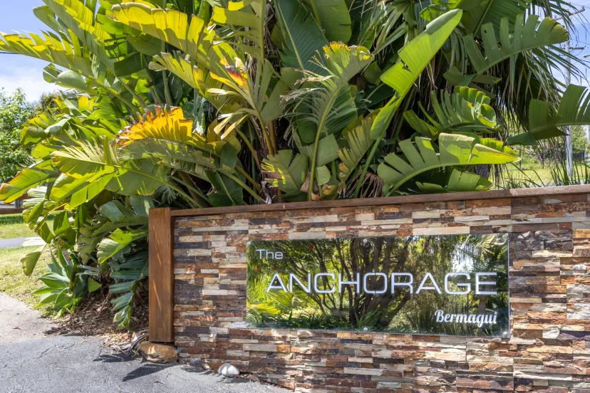 The Anchorage Bermagui stone entrance sign, surrounded by tropical planting