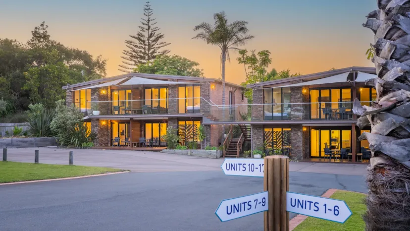 The apartment buildings at dusk, with signs directing guests to units 1 to 8