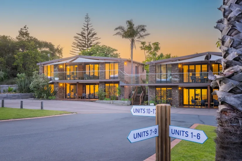 The apartment buildings at dusk, with signs directing guests to units 1 to 8