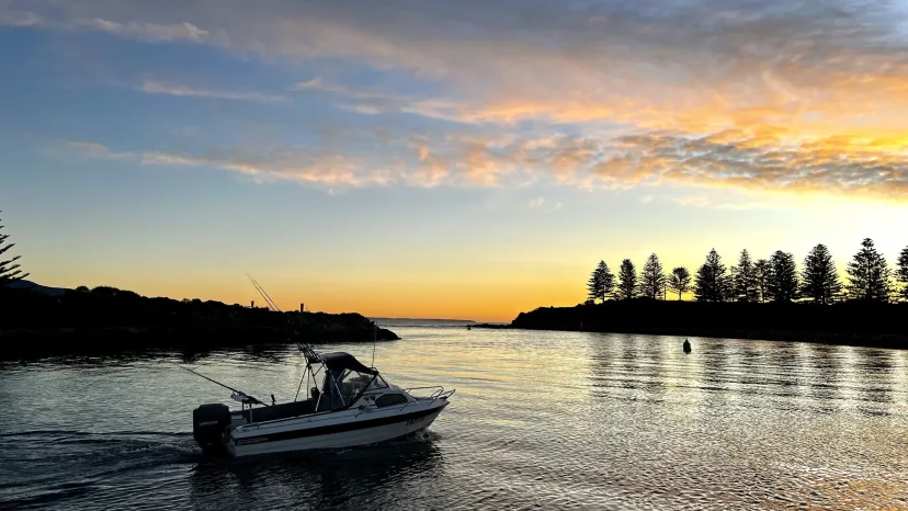 A fishing boat on calm water at sunset