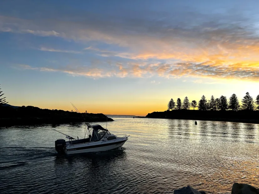 A fishing boat on calm water at sunset
