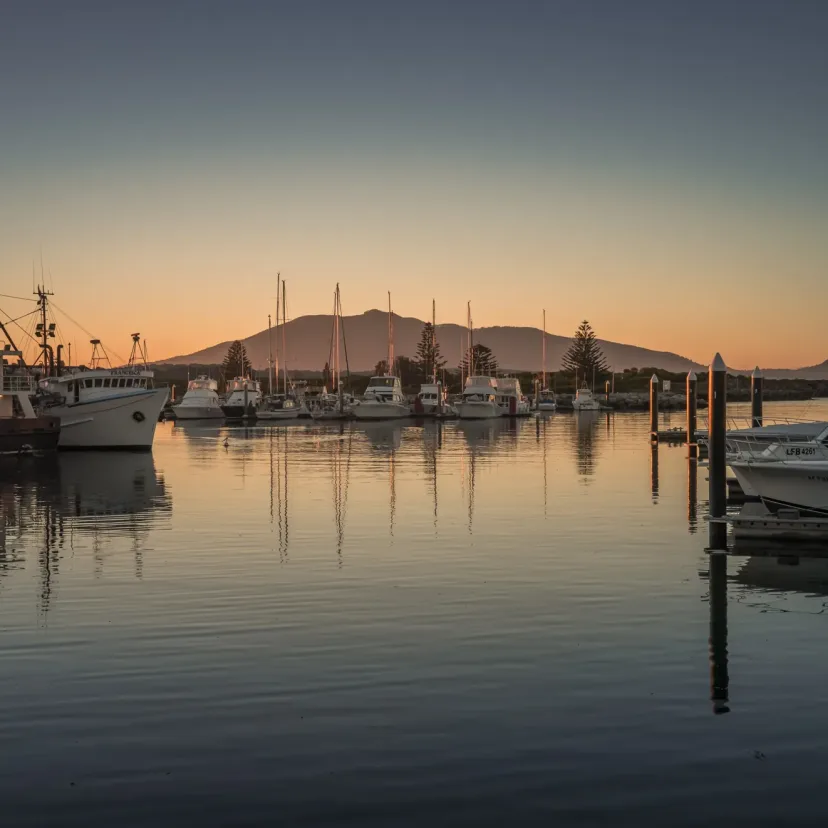 Bermagui harbour at sunset, with fishing boats at their moorings