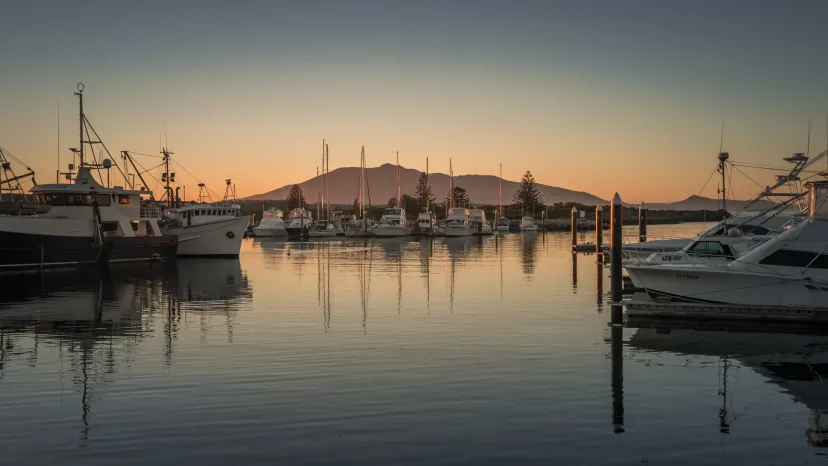 Bermagui harbour at sunset, with fishing boats at their moorings