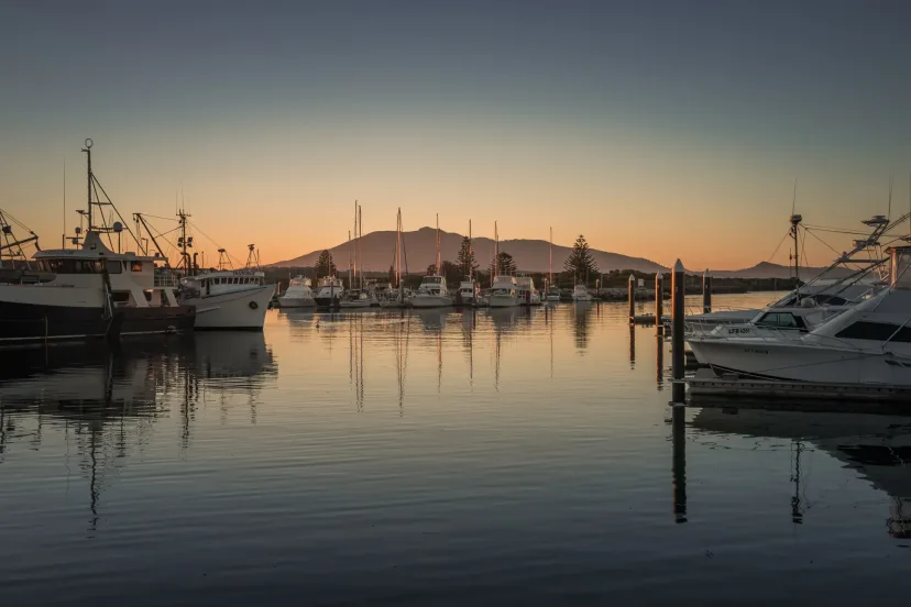Bermagui harbour at sunset, with fishing boats at their moorings